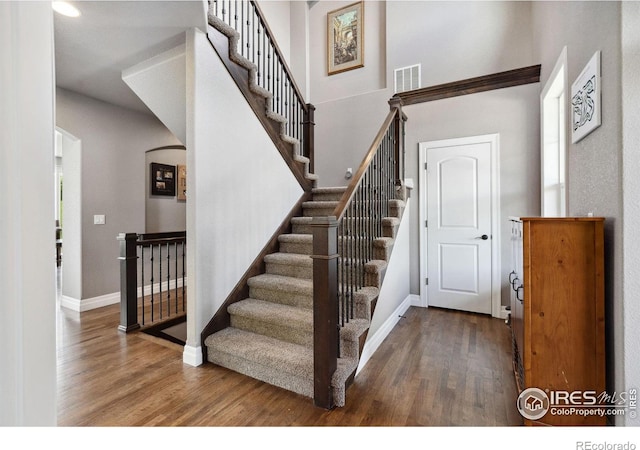 7427 Couples Ct, Fort Collins, CO 80528 - stairway with wood finished floors, arched walkways, and baseboards