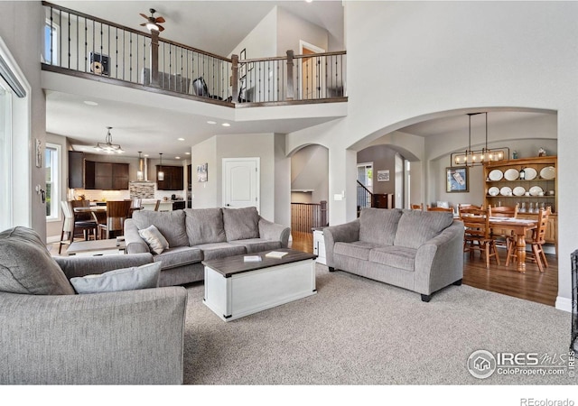 7427 Couples Ct, Fort Collins, CO 80528 - living room with a chandelier, arched walkways, carpet flooring, a towering ceiling, and recessed lighting