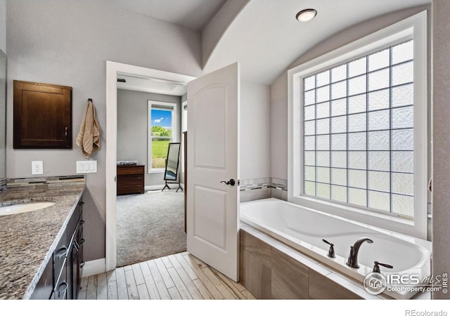 7427 Couples Ct, Fort Collins, CO 80528 - bathroom featuring a bath, vanity, wood finished floors, and baseboards