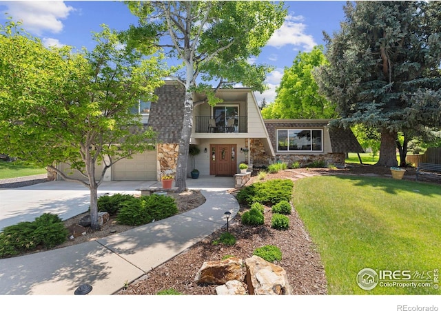 3804 Amy Pl, Loveland, CO 80538 - a-frame home featuring a balcony, concrete driveway, a front lawn, a garage, and stone siding