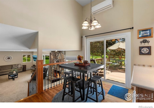 3804 Amy Pl, Loveland, CO 80538 - dining area featuring a wall mounted air conditioner, a high ceiling, a chandelier, light wood-style flooring, and a fireplace