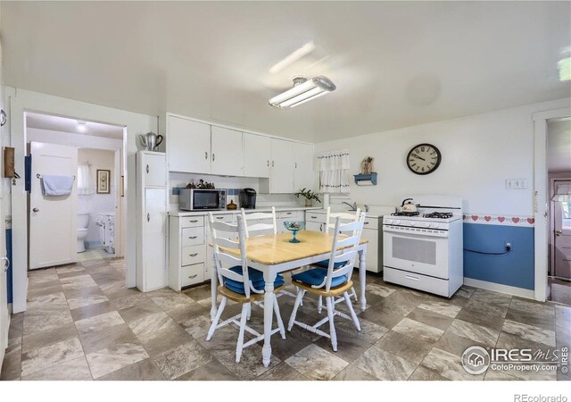 3833 Lincoln Ave, Wellington, CO 80549 - kitchen with gas range gas stove, stainless steel microwave, light countertops, and white cabinets