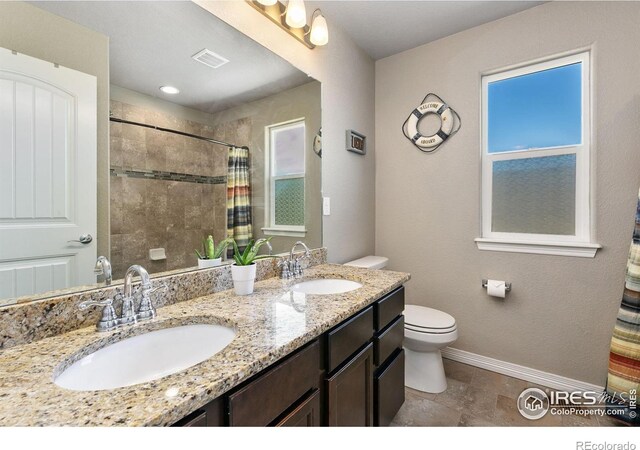 5664 Osbourne Dr, Windsor, CO 80550 - bathroom with toilet, a tile shower, double vanity, and baseboards