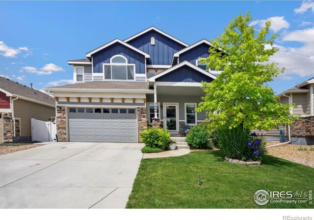 5664 Osbourne Dr, Windsor, CO 80550 - craftsman house featuring board and batten siding, driveway, stone siding, a garage, and a porch