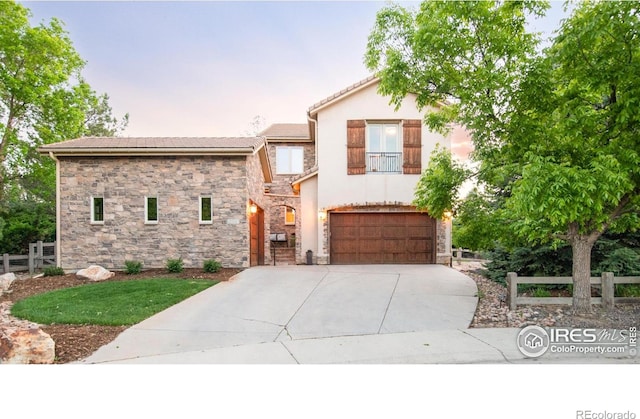 609 Corona Ct, Lafayette, CO 80026 - view of front of home featuring stone siding, concrete driveway, an attached garage, and stucco siding