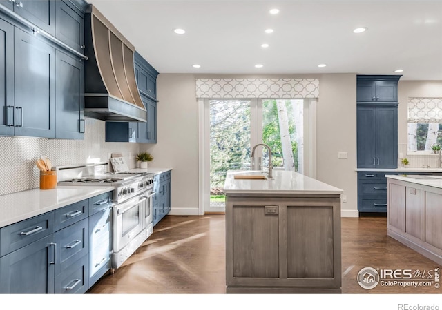 609 Corona Ct, Lafayette, CO 80026 - kitchen with range with two ovens, premium range hood, recessed lighting, a sink, and light countertops