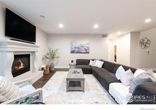 609 Corona Ct, Lafayette, CO 80026 - living room with wood finished floors, recessed lighting, a glass covered fireplace, and baseboards
