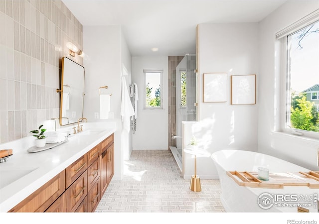 609 Corona Ct, Lafayette, CO 80026 - bathroom featuring a stall shower, double vanity, a freestanding tub, and tile walls
