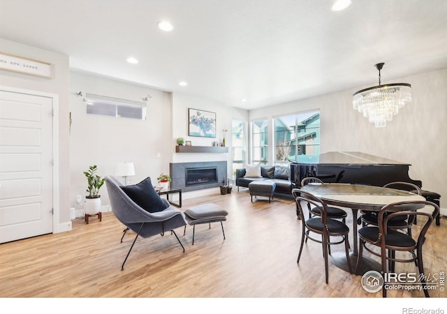 6211 Stable View St, Castle Pines, CO 80108 - living area featuring wood finished floors, a glass covered fireplace, recessed lighting, and a chandelier