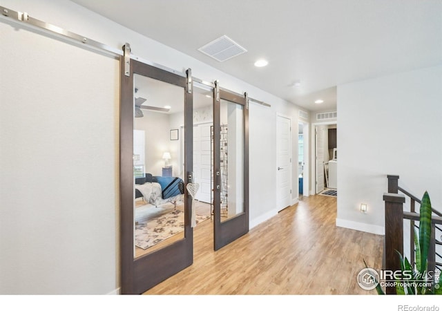 6211 Stable View St, Castle Pines, CO 80108 - hallway with a barn door, wood finished floors, recessed lighting, and baseboards