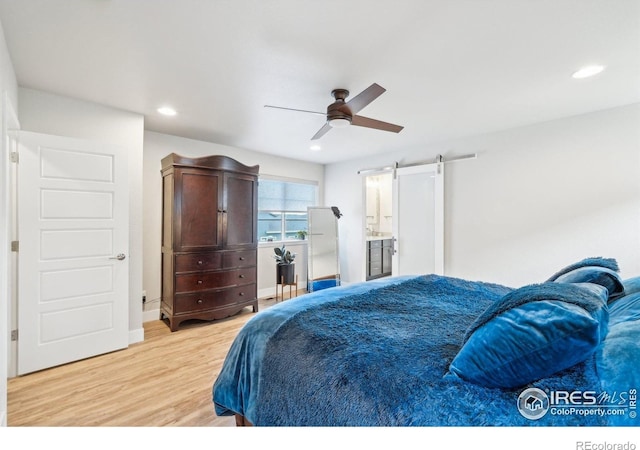6211 Stable View St, Castle Pines, CO 80108 - bedroom with light wood-type flooring, a barn door, recessed lighting, ceiling fan, and baseboards