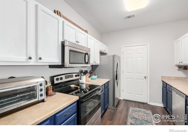 4451 S Ammons St Unit 307, Littleton, CO 80123 - kitchen with appliances with stainless steel finishes, blue cabinets, white cabinets, dark wood-style flooring, and light countertops