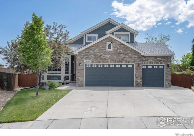 2085 Tundra Cir, Erie, CO 80516 - craftsman-style house with driveway, brick siding, and an attached garage