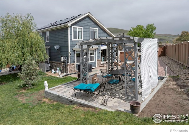 2085 Tundra Cir, Erie, CO 80516 - back of property featuring a pergola, brick siding, solar panels, and a patio