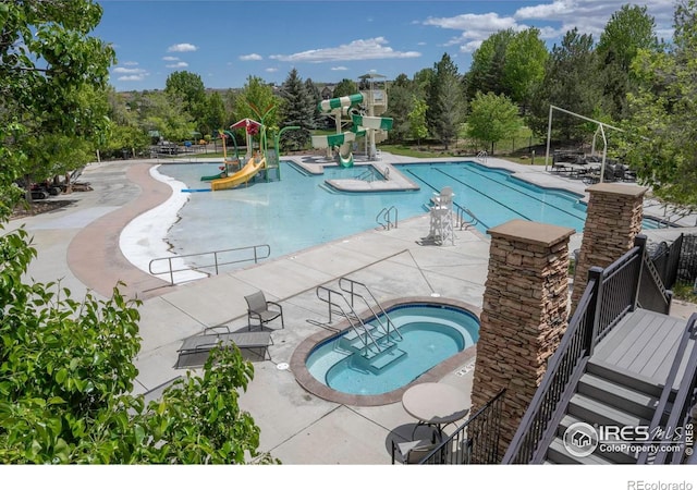 2085 Tundra Cir, Erie, CO 80516 - community pool with a community hot tub, a water slide, a patio area, and view of scattered trees