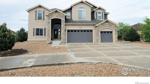 3106 Megan Way, Berthoud, CO 80513 - view of front facade featuring stone siding, stucco siding, an attached garage, and concrete driveway