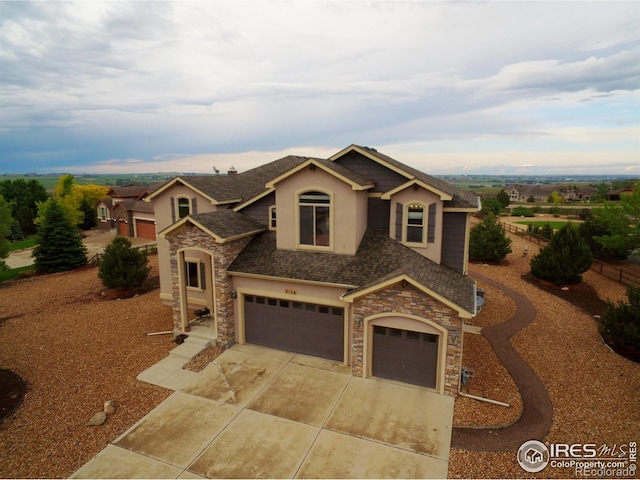 3106 Megan Way, Berthoud, CO 80513 - view of front of home featuring stone siding, stucco siding, concrete driveway, and an attached garage