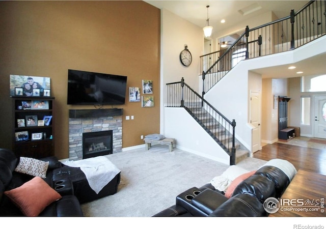 3106 Megan Way, Berthoud, CO 80513 - living room with stairway, baseboards, a high ceiling, a fireplace, and recessed lighting