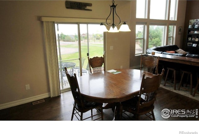 3106 Megan Way, Berthoud, CO 80513 - dining area with healthy amount of natural light, wood finished floors, baseboards, and a chandelier