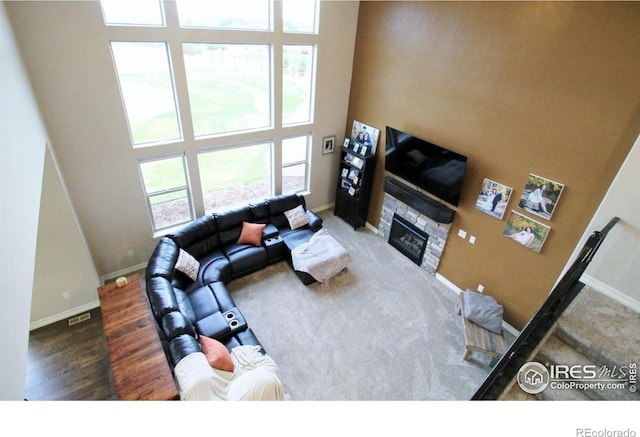 3106 Megan Way, Berthoud, CO 80513 - living area featuring a fireplace, a high ceiling, baseboards, and wood finished floors