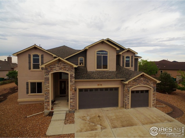 3106 Megan Way, Berthoud, CO 80513 - view of front of property featuring stone siding, stucco siding, roof with shingles, driveway, and an attached garage