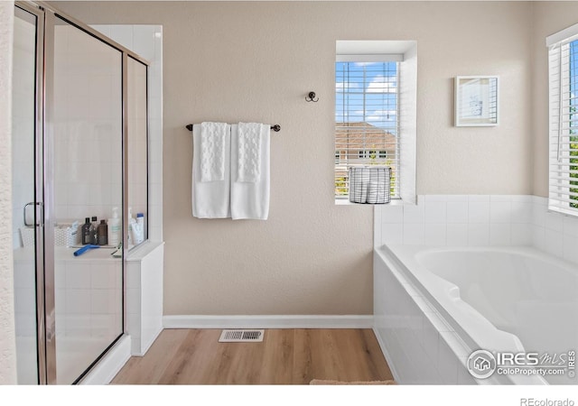 23570 E Holly Hills Way, Parker, CO 80138 - full bathroom with wood finished floors, a garden tub, a shower stall, baseboards, and a textured wall