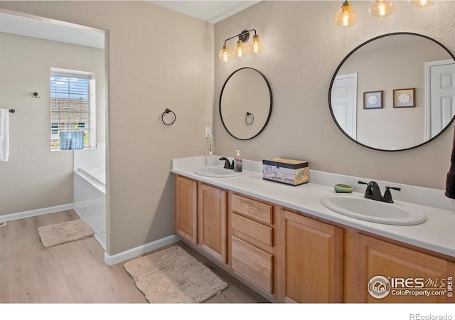 23570 E Holly Hills Way, Parker, CO 80138 - full bathroom with wood finished floors, double vanity, a tub, and baseboards