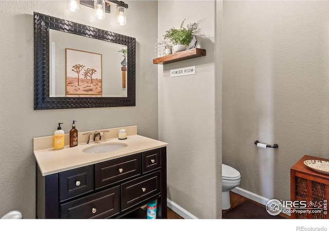 23570 E Holly Hills Way, Parker, CO 80138 - half bathroom with toilet, vanity, wood finished floors, and baseboards