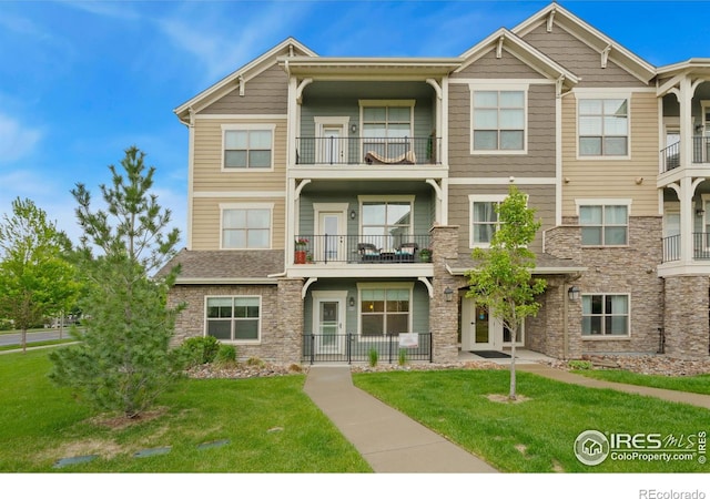 4672 Hahns Peak Dr Unit 101, Loveland, CO 80538 - view of front of home with stone siding and a front yard