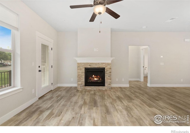 4672 Hahns Peak Dr Unit 101, Loveland, CO 80538 - unfurnished living room with a fireplace, ceiling fan, light wood-style floors, and baseboards