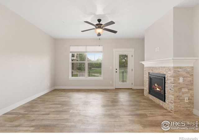 4672 Hahns Peak Dr Unit 101, Loveland, CO 80538 - unfurnished living room featuring a glass covered fireplace, wood finished floors, ceiling fan, and baseboards
