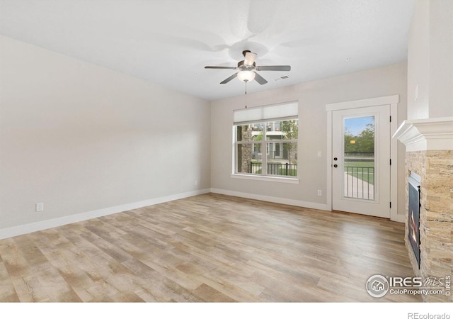 4672 Hahns Peak Dr Unit 101, Loveland, CO 80538 - unfurnished living room featuring ceiling fan, a fireplace, light wood-style flooring, and baseboards