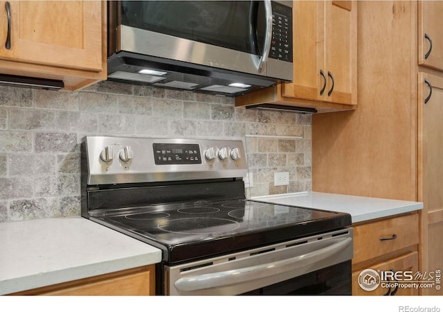 4672 Hahns Peak Dr Unit 101, Loveland, CO 80538 - kitchen featuring stainless steel appliances, decorative backsplash, and light countertops