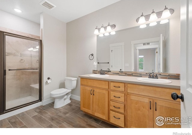 4672 Hahns Peak Dr Unit 101, Loveland, CO 80538 - bathroom with double vanity, toilet, a stall shower, wood finished floors, and baseboards