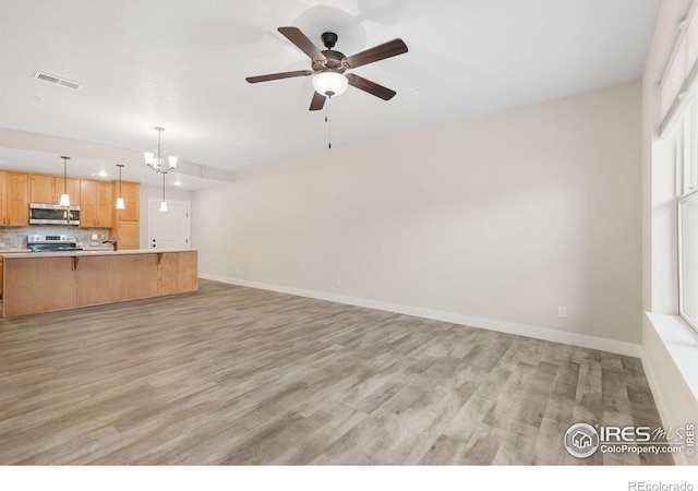 4672 Hahns Peak Dr Unit 101, Loveland, CO 80538 - unfurnished living room featuring light wood finished floors, baseboards, ceiling fan, and a chandelier