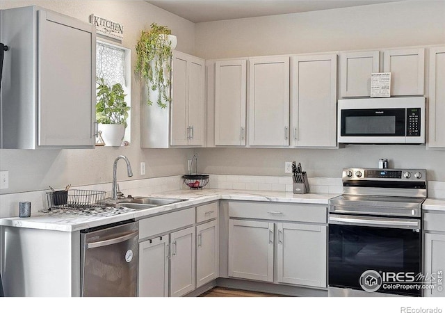608 Apex Trl, Ault, CO 80610 - kitchen with stainless steel appliances, light countertops, and a sink