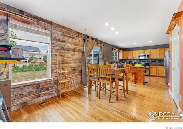 1086 Mockingbird St, Brighton, CO 80601 - dining area with light wood-style floors, wood walls, and recessed lighting