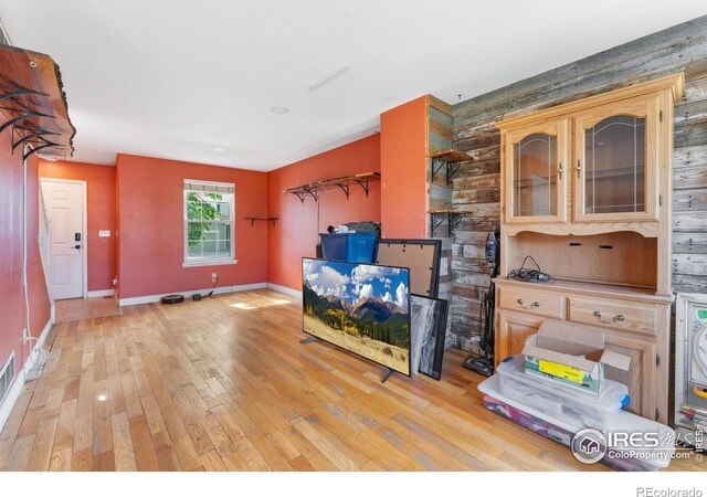 1086 Mockingbird St, Brighton, CO 80601 - living area featuring light wood-type flooring, baseboards, and wooden walls