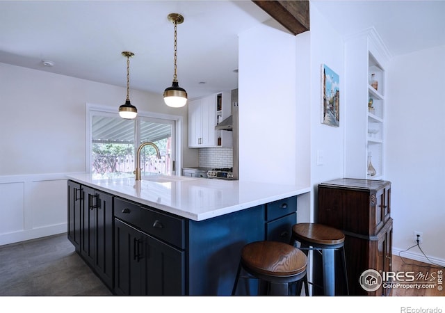 855 33rd St, Boulder, CO 80303 - kitchen with a sink, a kitchen bar, decorative light fixtures, white cabinets, and tasteful backsplash