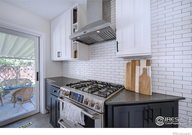 855 33rd St, Boulder, CO 80303 - kitchen with wall chimney range hood, stainless steel gas stove, dark countertops, white cabinets, and decorative backsplash