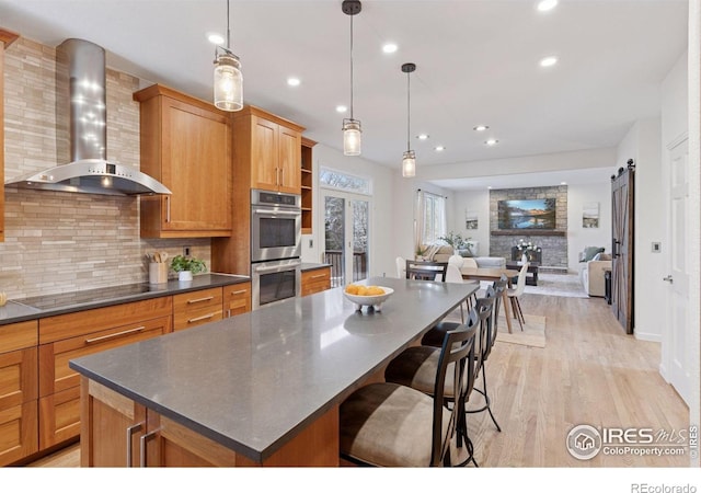 4094 Bimini Ct, Boulder, CO 80301 - kitchen with wall chimney range hood, double oven, stovetop, dark countertops, and light wood-style floors