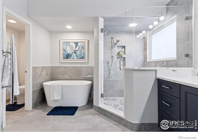 4094 Bimini Ct, Boulder, CO 80301 - bathroom with a shower stall, vanity, a soaking tub, tile walls, and toilet