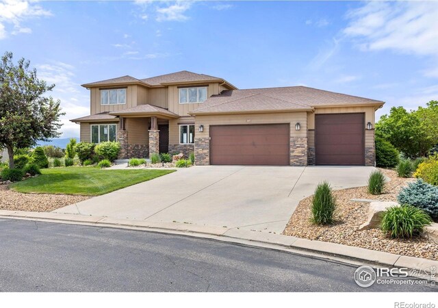 873 Signal Ct, Timnath, CO 80547 - prairie-style home featuring stone siding, a garage, a front yard, and concrete driveway
