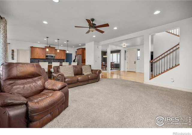 873 Signal Ct, Timnath, CO 80547 - living area with light colored carpet, ceiling fan, recessed lighting, stairway, and baseboards