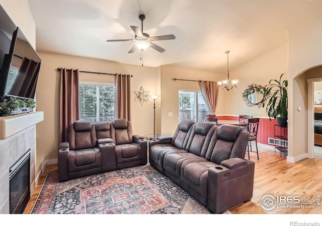 405 Timber Ridge Parkway, Severance, CO 80550 - living room with a chandelier, a fireplace, a ceiling fan, light wood finished floors, and arched walkways