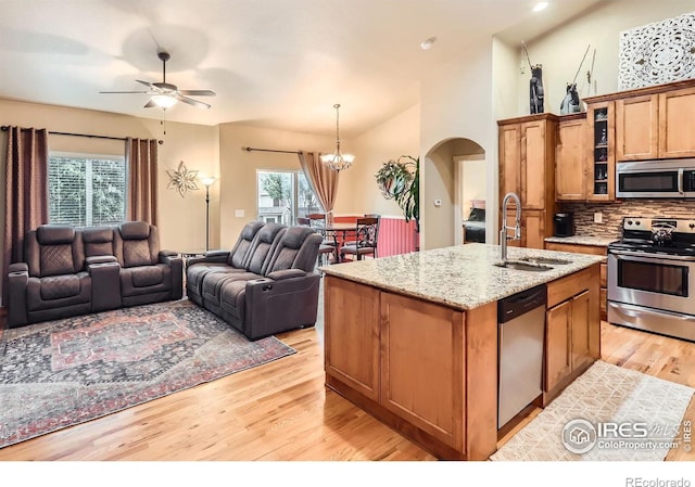 405 Timber Ridge Parkway, Severance, CO 80550 - kitchen featuring appliances with stainless steel finishes, open floor plan, arched walkways, a sink, and ceiling fan
