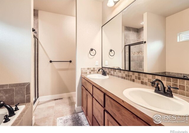 405 Timber Ridge Parkway, Severance, CO 80550 - bathroom with a stall shower, a garden tub, double vanity, and decorative backsplash
