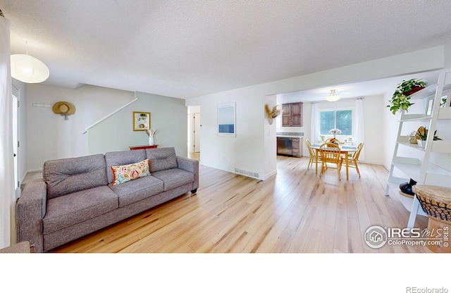 2415 Sunray Ct, Fort Collins, CO 80525 - living area featuring light wood-type flooring, a textured ceiling, and baseboards