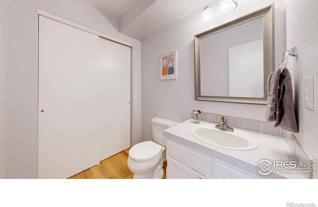 2415 Sunray Ct, Fort Collins, CO 80525 - bathroom with toilet, vanity, and wood finished floors