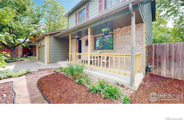 2415 Sunray Ct, Fort Collins, CO 80525 - view of front of home featuring covered porch, brick siding, a garage, and driveway